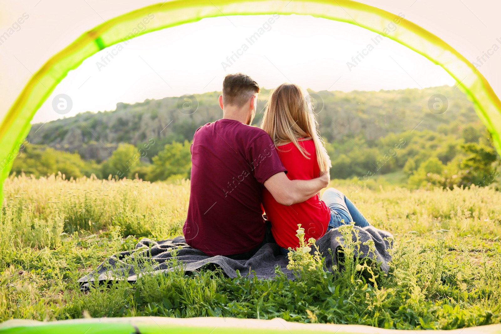 Photo of Lovely couple spending time together in wilderness, view from inside of camping tent