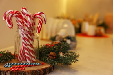 Photo of Christmas decor and candy canes on countertop in kitchen, closeup. Space for text