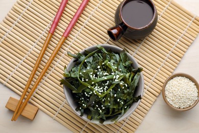 Photo of Fresh laminaria (kelp) seaweed served on wooden table, flat lay