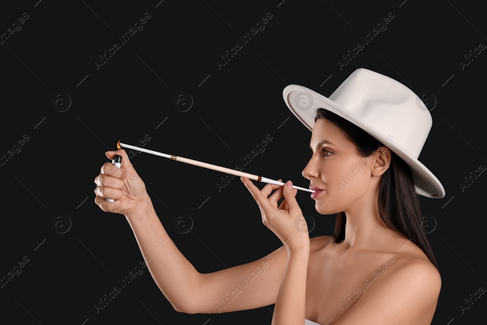 Photo of Woman using long cigarette holder for smoking on black background