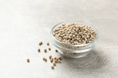 Aromatic spice. White pepper in bowl on light grey table, space for text