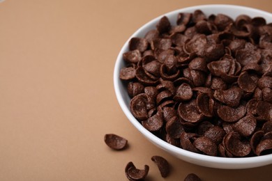 Breakfast cereal. Chocolate corn flakes in bowl on brown table, closeup. Space for text