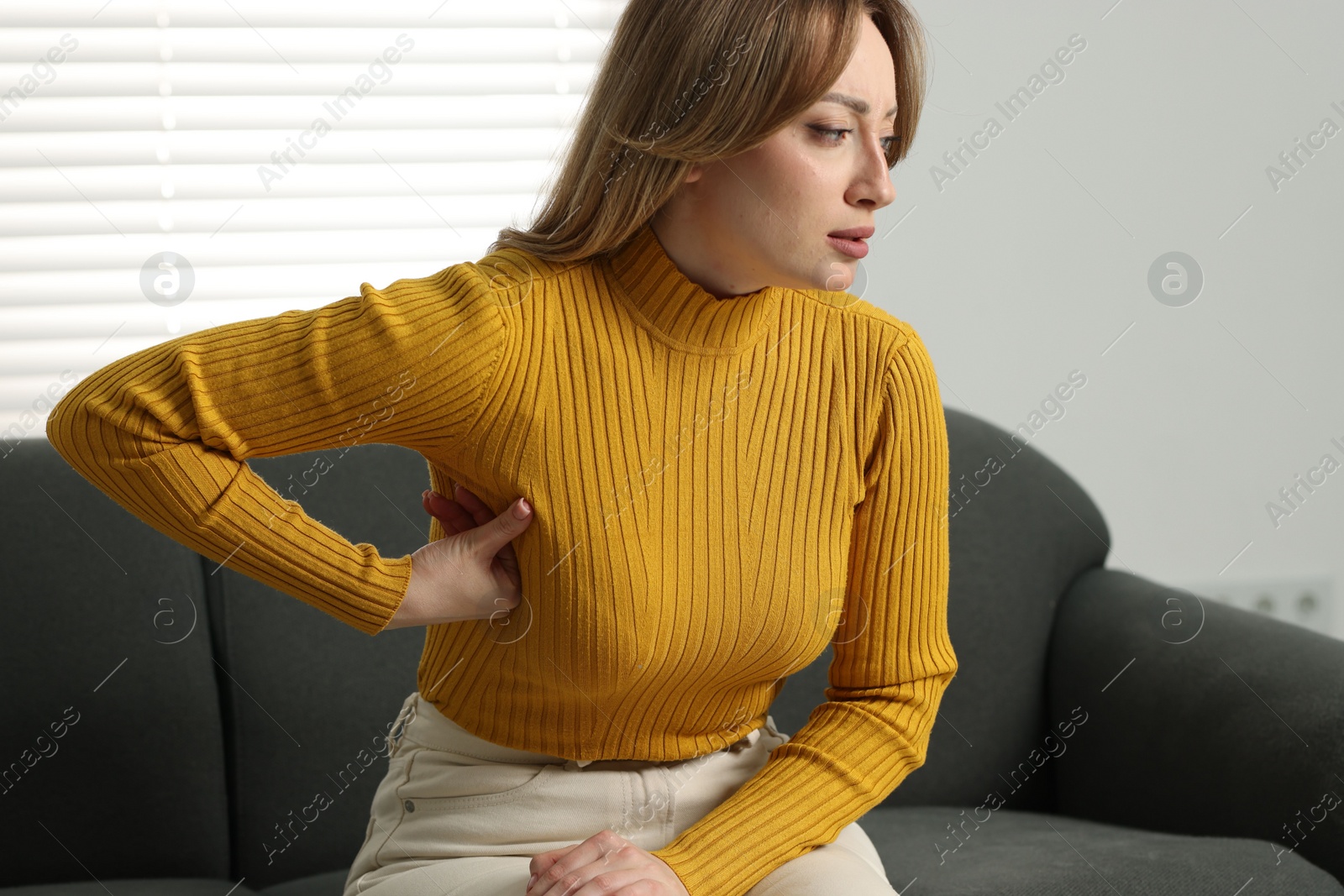 Photo of Mammology. Young woman doing breast self-examination at home