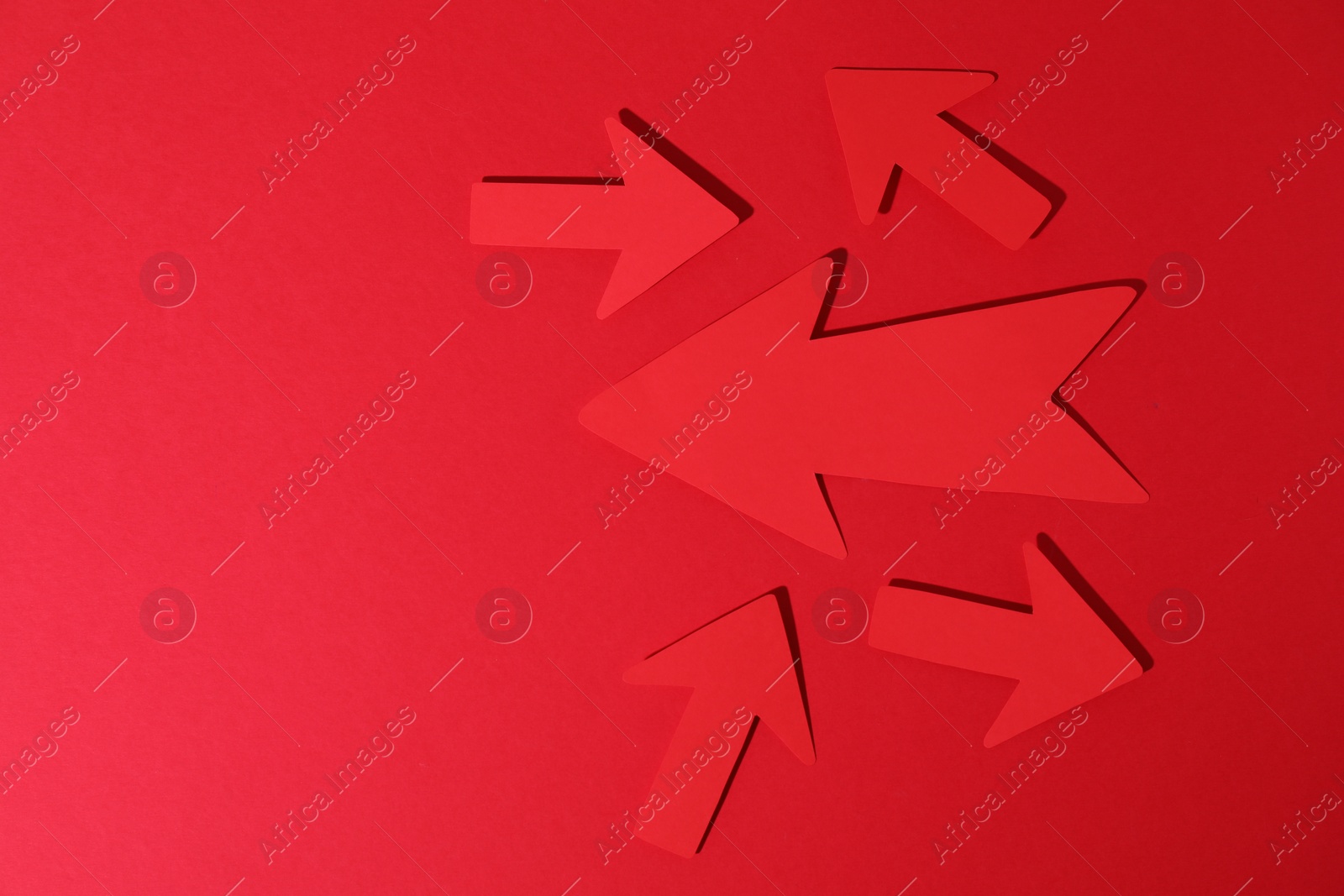 Photo of Many paper arrows on red background, flat lay. Space for text