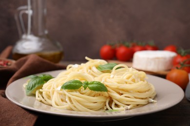 Photo of Delicious pasta with brie cheese and basil leaves on table, closeup