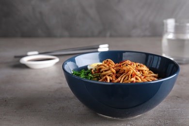 Photo of Bowl of noodles with spices and egg on table