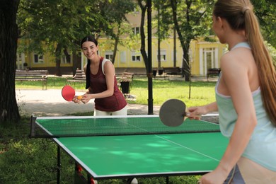 Photo of Young women playing ping pong in park