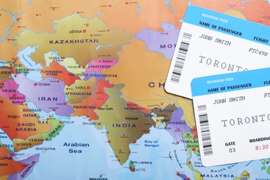 Photo of Avia tickets on world map, flat lay. Travel agency concept