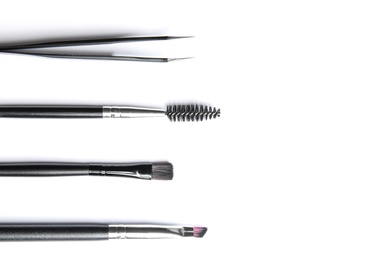 Set of professional eyebrow tools on white background, top view