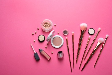 Flat lay composition with makeup brushes on pink background