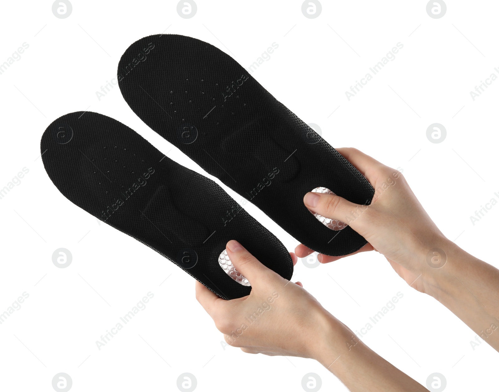 Photo of Woman holding pair of black orthopedic insoles on white background, closeup