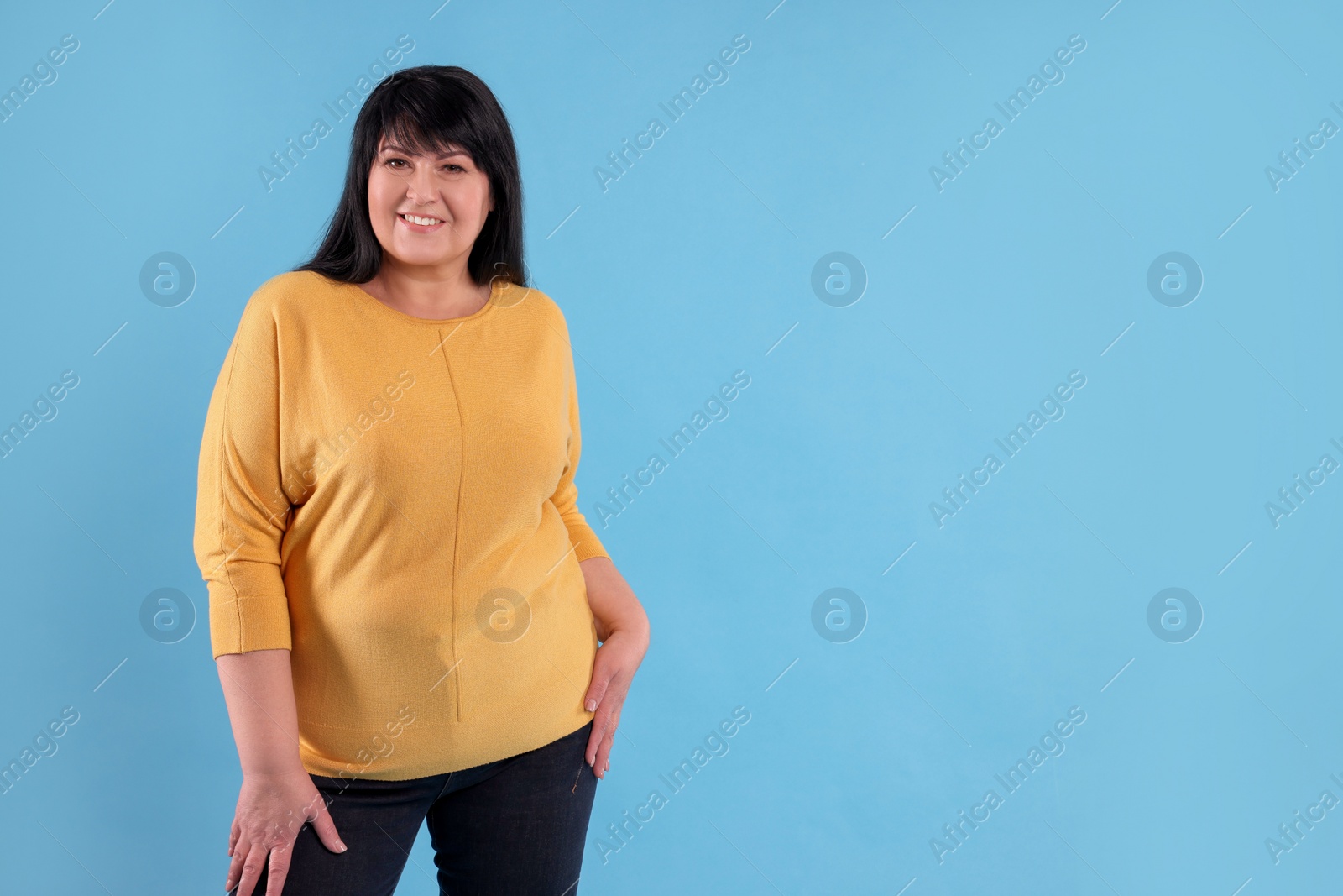 Photo of Beautiful overweight mature woman with charming smile on turquoise background. Space for text