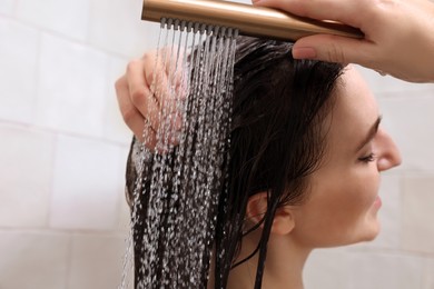 Photo of Young woman washing hair while taking shower at home