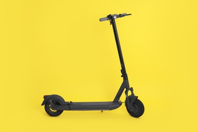 Photo of Modern electric kick scooter on yellow background