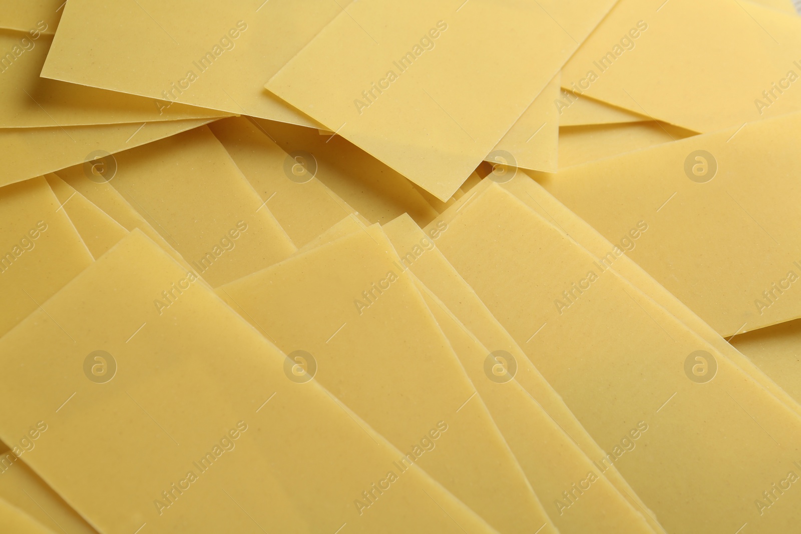 Photo of Pile of dry lasagna sheets as background, closeup