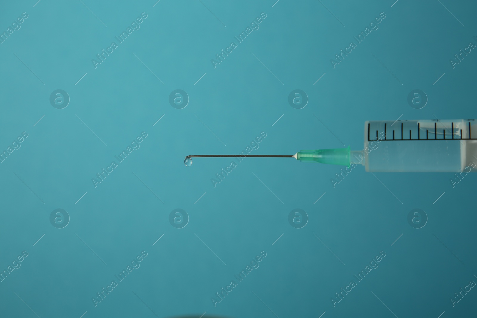 Photo of Medical syringe on light blue background, closeup. Space for text