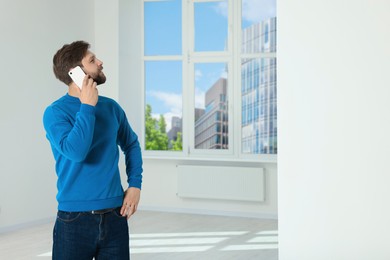 Man in casual clothes talking on phone indoors, space for text