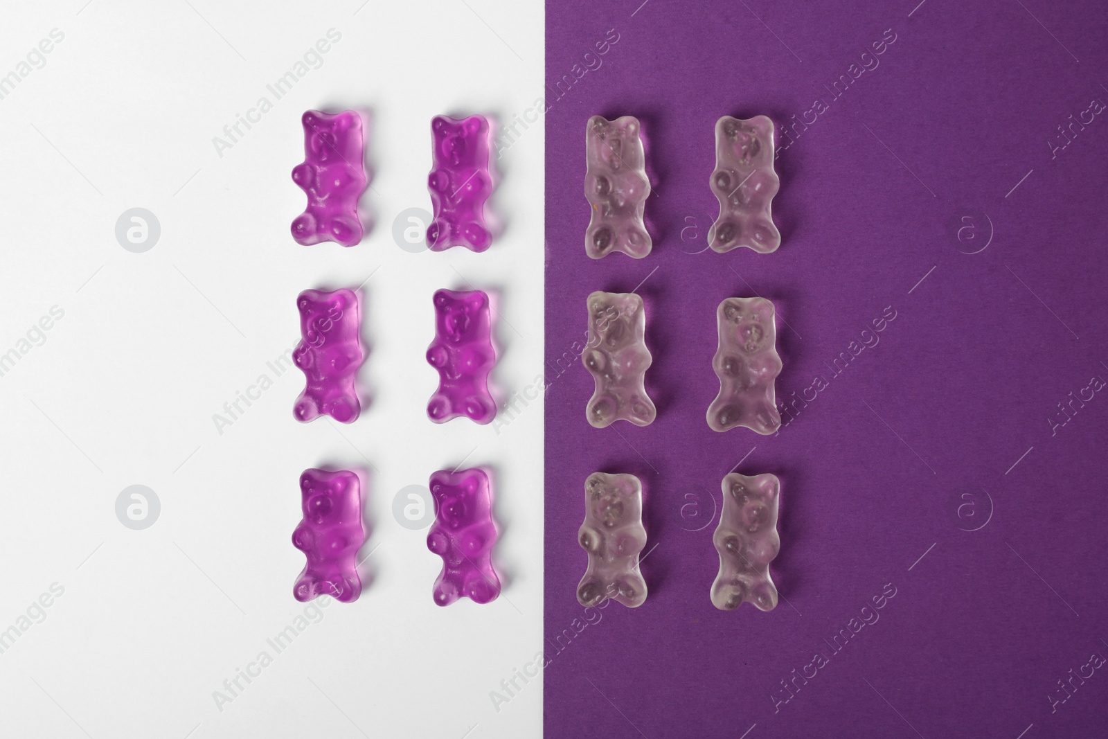 Photo of Delicious little jelly bears on color background, flat lay