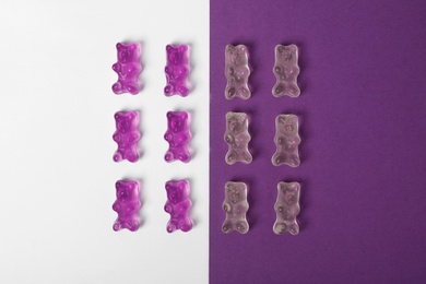 Delicious little jelly bears on color background, flat lay