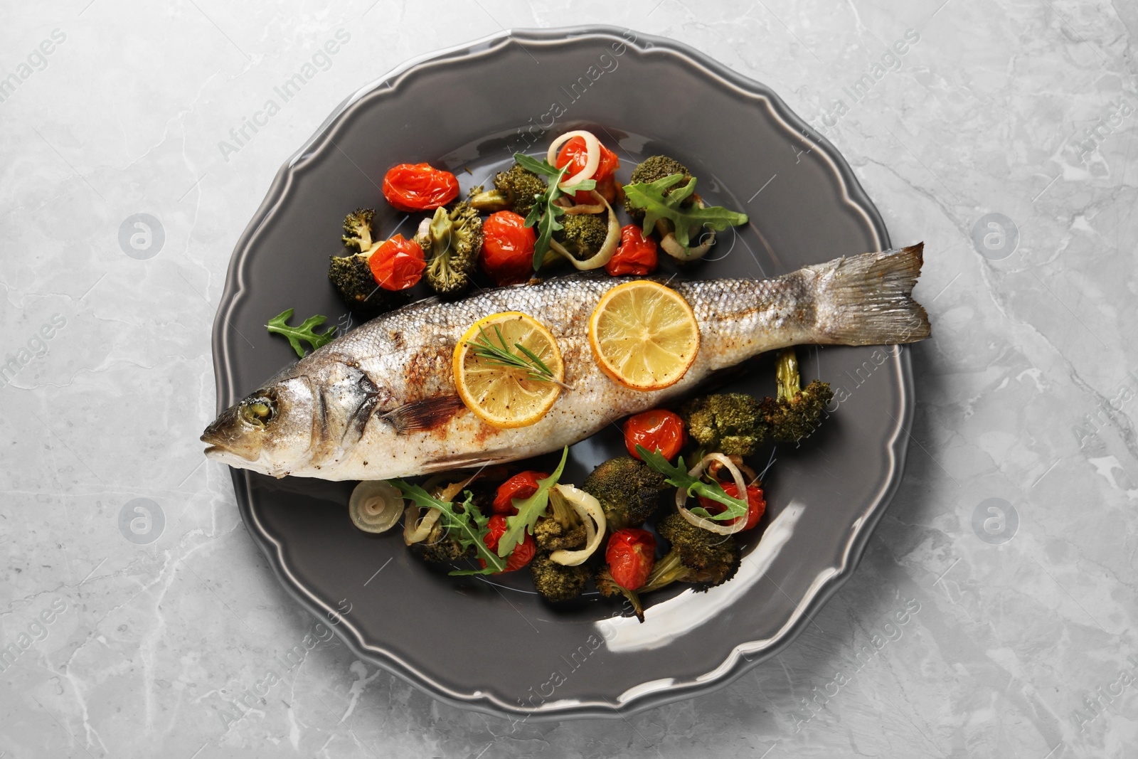 Photo of Baked fish with vegetables, rosemary and lemon on grey textured table, top view