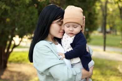 Family portrait of happy mother and her baby in park