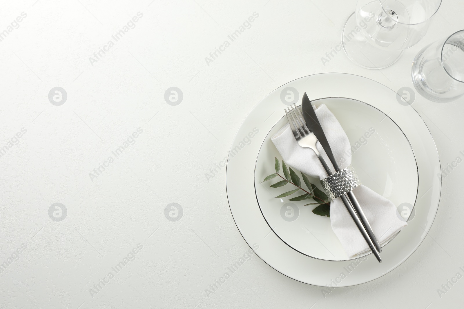 Photo of Stylish setting with cutlery and napkin on white textured table, top view. Space for text