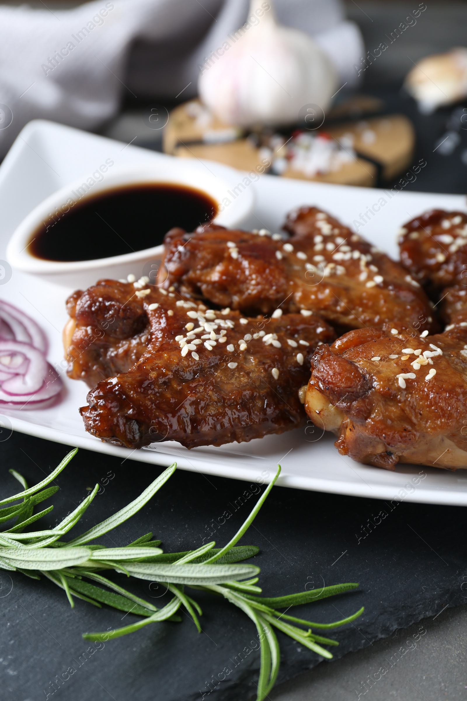 Photo of Chicken wings glazed with soy sauce served on table, closeup