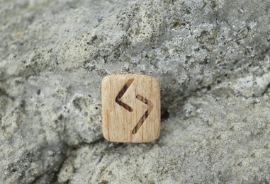 Wooden rune Jera on stone outdoors, closeup