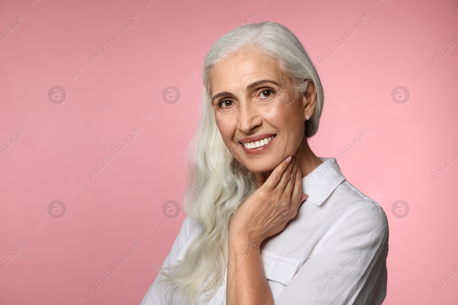 Photo of Portrait of beautiful mature woman on pink background, space for text