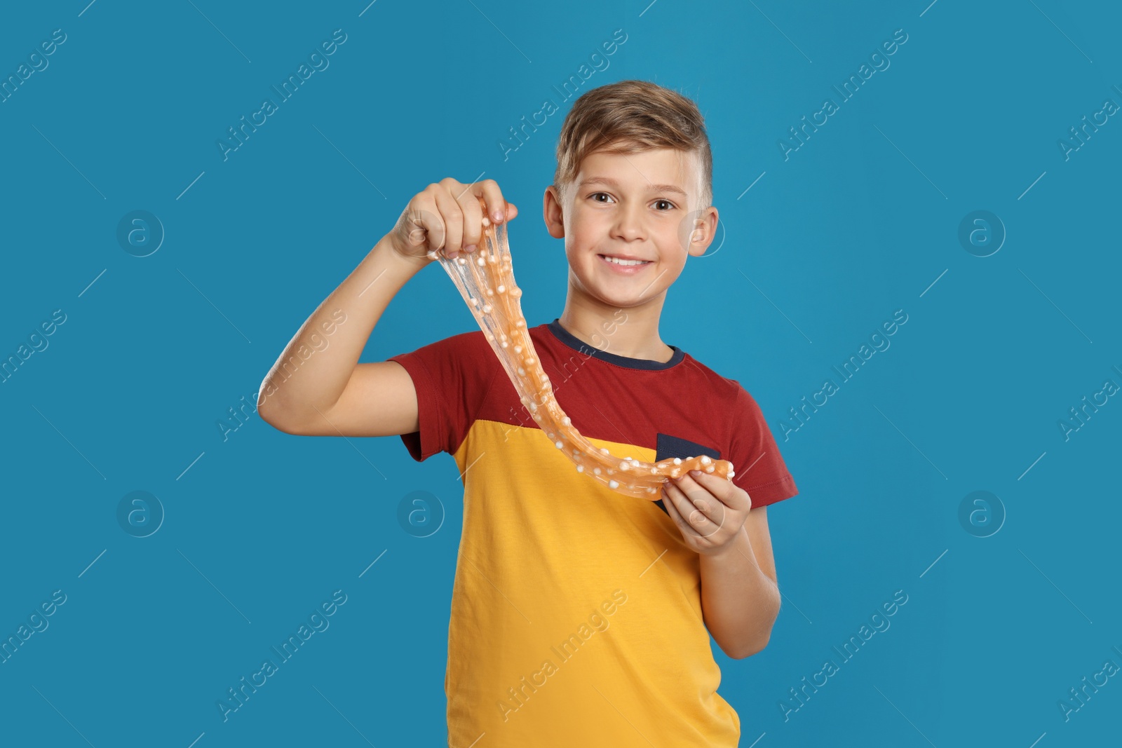 Photo of Preteen boy with slime on blue background