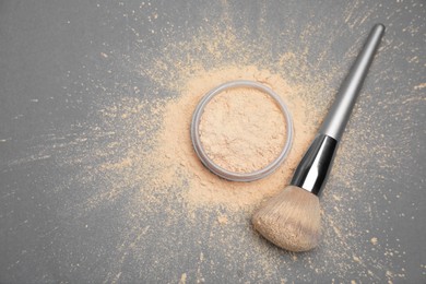 Photo of Loose face powder and makeup brush on grey background, flat lay