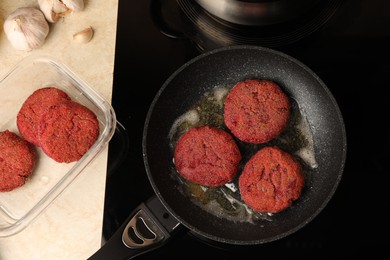 Photo of Frying vegan cutlets on cooktop, flat lay