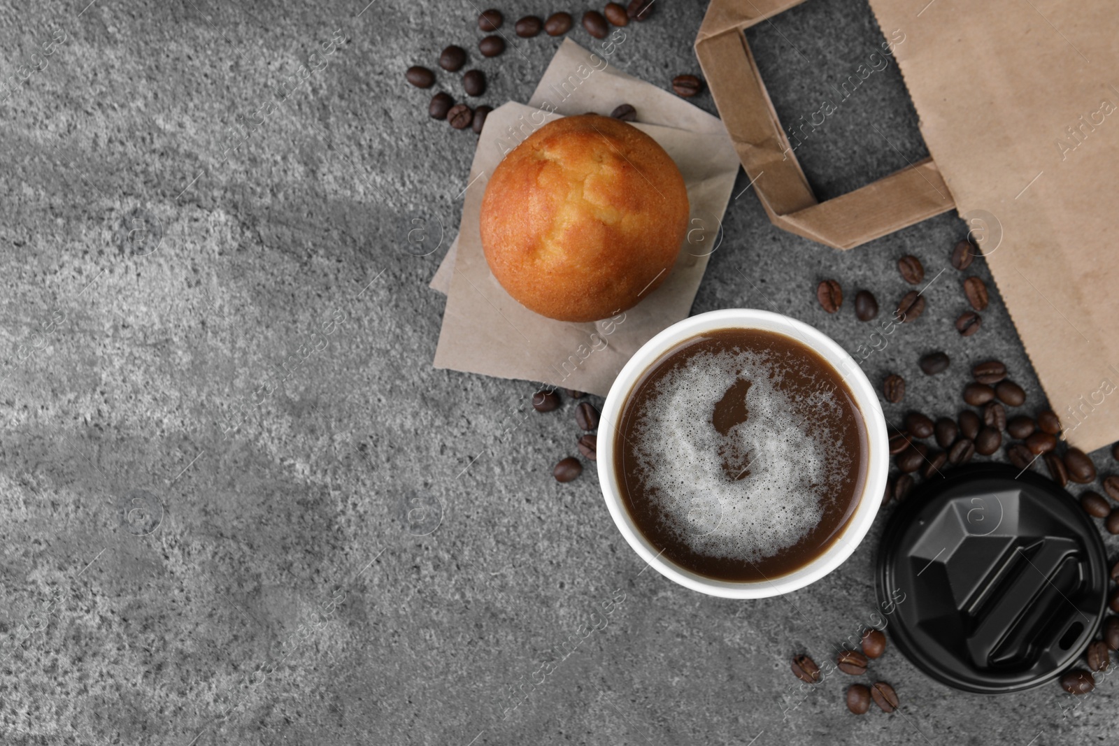 Photo of Coffee to go. Paper cup of tasty drink, muffin and beans on grey table, flat lay with space for text