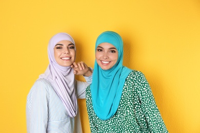 Photo of Portrait of young Muslim women in hijabs against color background