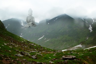 Majestic Buddha sculpture rising above picturesque mountains