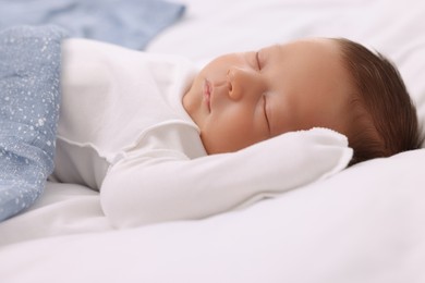 Photo of Cute newborn baby sleeping under blue blanket on bed, closeup