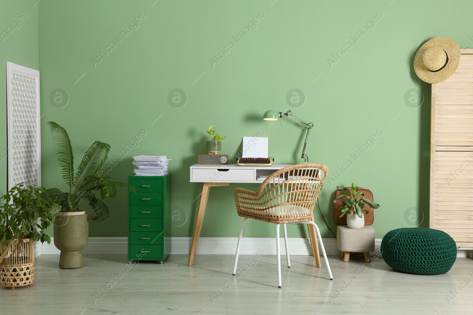 Photo of Writer's workplace with typewriter on wooden desk near pale green wall in room