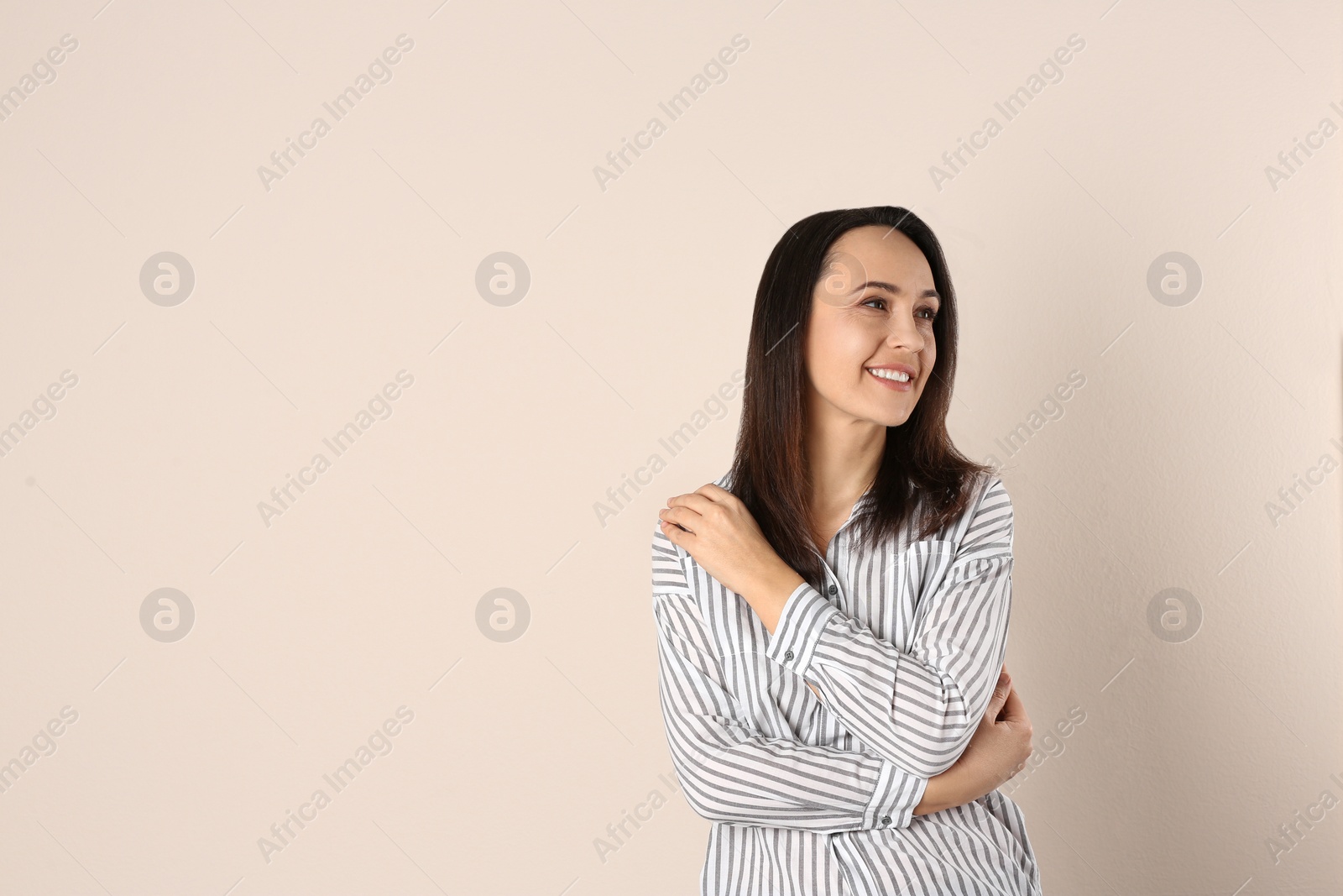 Photo of Portrait of beautiful mature woman on beige background. Space for text