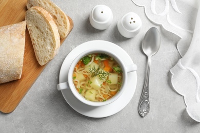 Photo of Dish of fresh homemade vegetable soup served on light grey table, flat lay