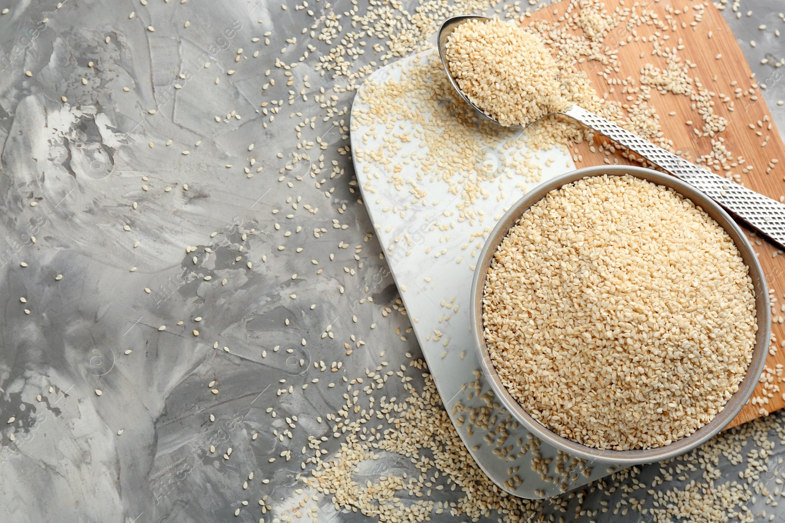 Photo of White sesame seeds on light grey table, flat lay. Space for text