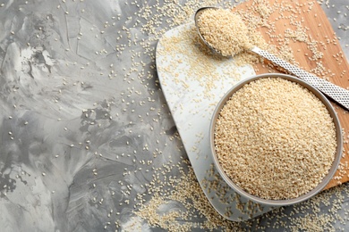 Photo of White sesame seeds on light grey table, flat lay. Space for text