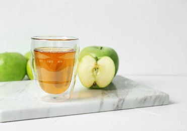 Photo of Glass of apple juice on marble board