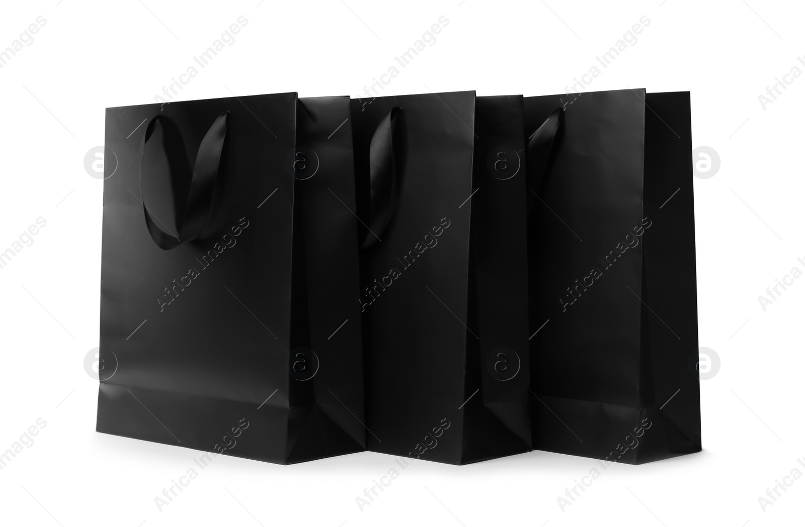 Photo of Paper shopping bags with ribbon handles on white background. Mockup for design