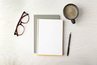 Photo of Flat lay composition with office stationery and cup of coffee on white wooden table. Space for design