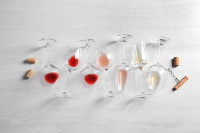 Photo of Different glasses with wine on light background, flat lay