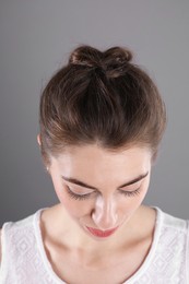 Woman with braided hair on grey background