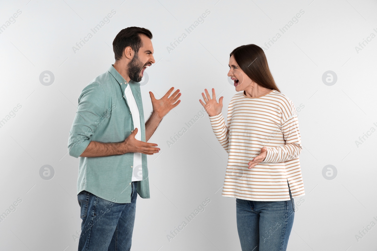 Photo of Couple quarreling on light background. Relationship problems