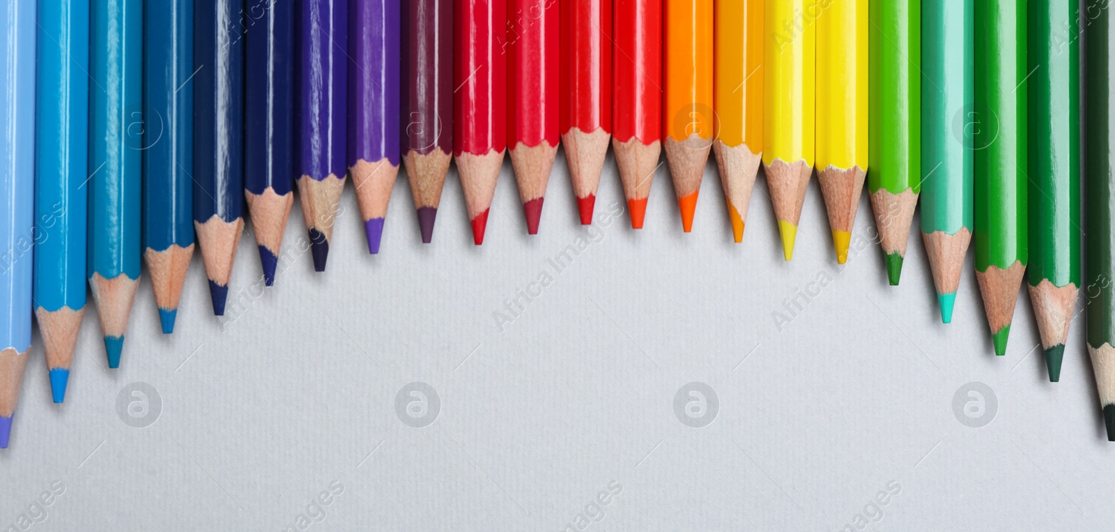 Photo of Colorful pencils on light background, flat lay. Space for text