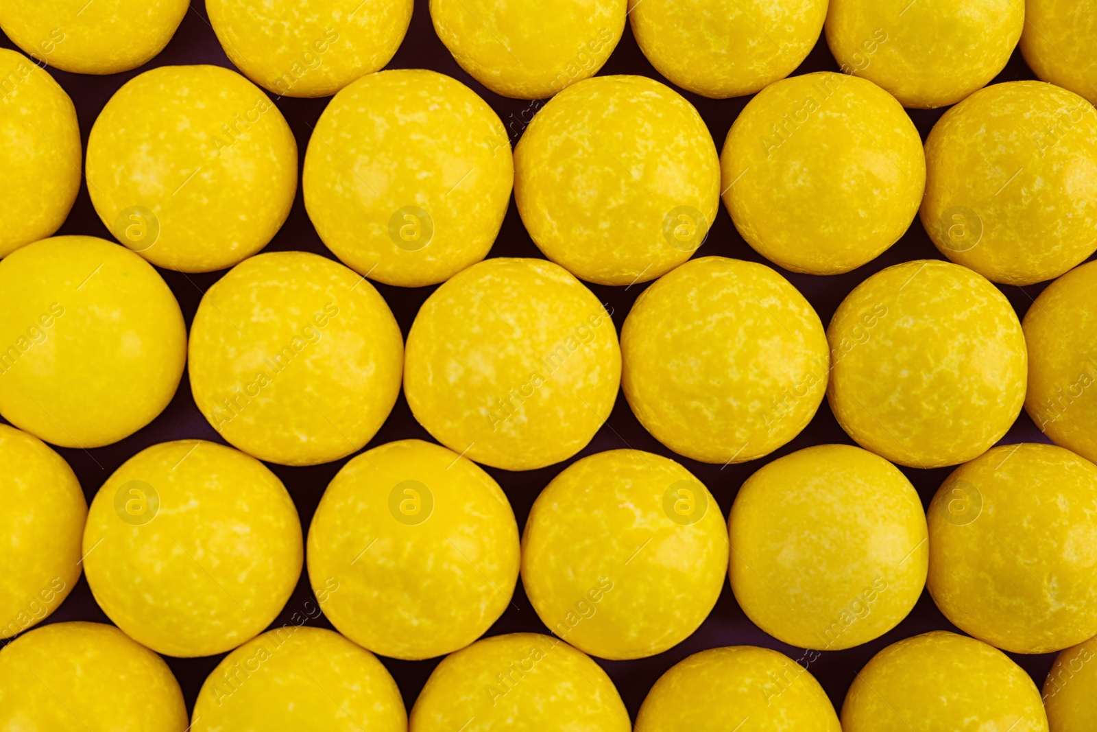 Photo of Delicious lemon chewing gums as background, top view