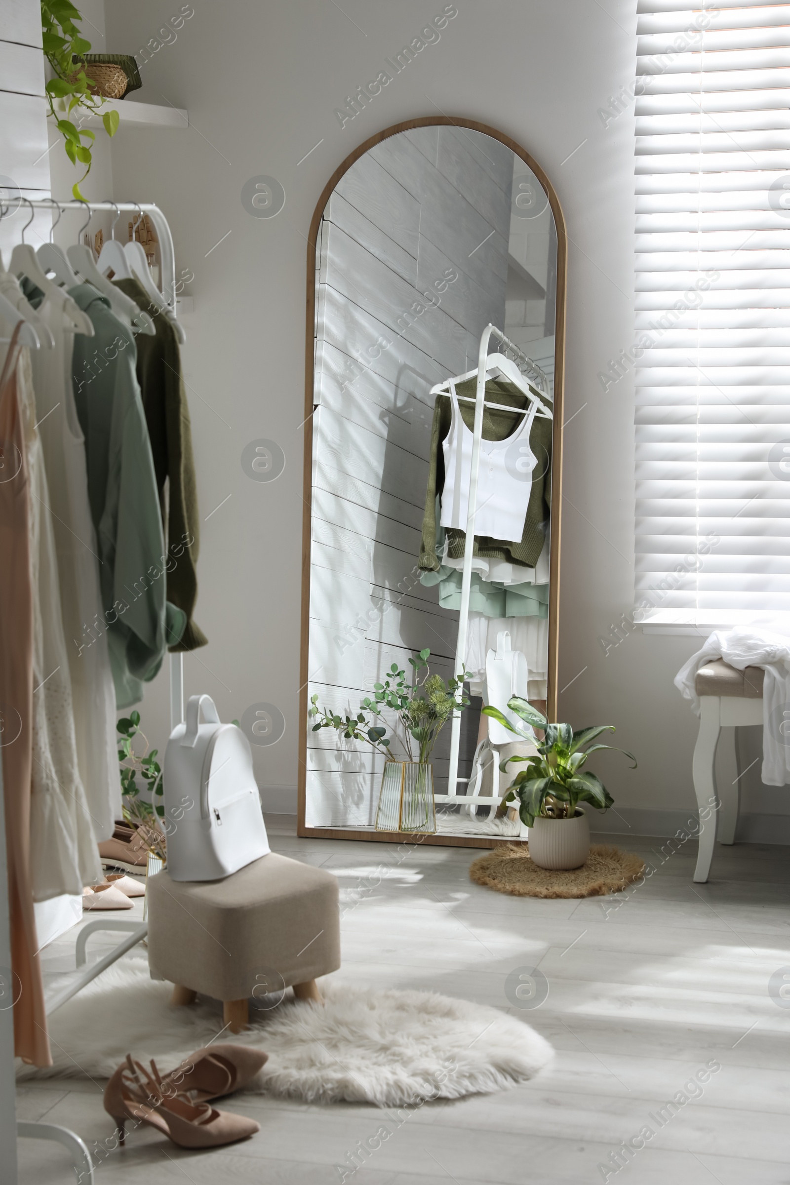 Photo of Rack with different stylish clothes, shoes and decorative elements in dressing room. Interior design